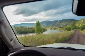 Road trip to remote villages in Siberia and Russia river view. Scenic drive alongside a river in a mountain valley during late afternoon