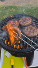Juicy Burgers Being Grilled Outdoors with Open Flame and Smoke