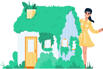 Woman presenting eco friendly house covered by green plants