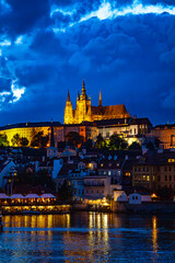 Fototapeta premium Prague Castle and St. Vitus Cathedral Illuminated at Night with Reflections on the Vltava River in Prague, Czech Republic, Famous UNESCO World Heritage Site and Popular European Travel Destination