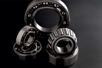 several roller bearings on black background
