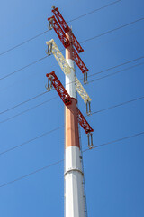 Power lines stretching across a vibrant blue sky on transmission tower