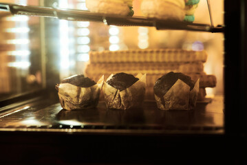 Delicious chocolate muffins in a bakery display, ready for a tasty treat.
