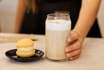A glass of latte with a cookie, a delightful and inviting beverage.