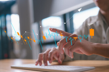 Hands typing on keyboard and pointing at trading chart in concept of market analysis financial and...