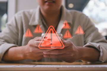 businessman using smartphone with virtual triangle caution sign, investment risk management strategy Category Business cyber security
