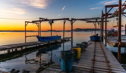An oyster boat on a pontoon on the Thau lagoon at sunrise, in Occitanie, France