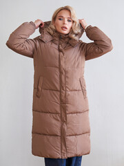 Stylish and Warm Women's Brown Long Puffer Coat Perfect for Cold Weather, Featuring a Cozy Hood and...