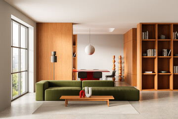 Modern minimalist living room and dining area with green sofa, wooden shelves, and red dining table...