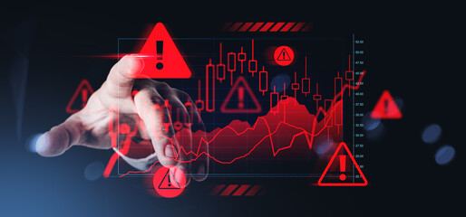 Hand interacting with digital chart showing financial crisis warning symbols and negative trend...