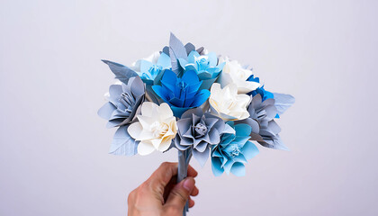 bouquet of blue and purple flowers held in hand with petals and leaves visible