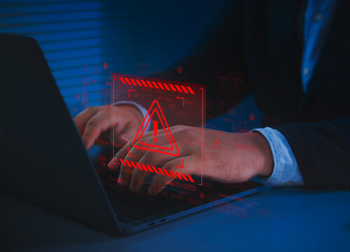Cybersecurity warning alert with businessman typing on laptop showing digital red error sign for data breach, malware attack, and online security risk prevention