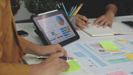 Financial analysts analyze business financial reports on a digital tablet planning investment project during a discussion at a meeting of corporate showing the results of their successful teamwork. - Powered by Adobe