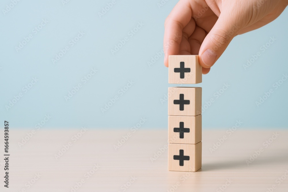 Poster adding value: hand stacking wooden blocks with plus signs for positive growth and success