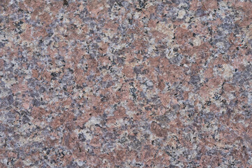 Close-up view of speckled pink and grey granite stone texture with granular pattern and rough surface detail