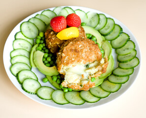 Close Up of Smoked Haddock Fishcake Happy Face with Mature Cheddar Cheese, Strawberry, Avocado, Cucumber and Green Peas, Healthy Organic Diet