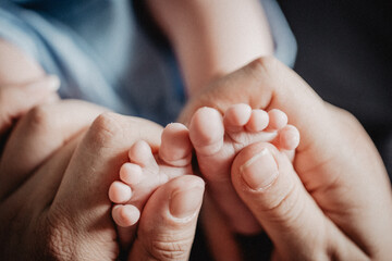 Mutter hält Babyfüße in Hand - Nähe, Geborgenheit, unendliche Liebe