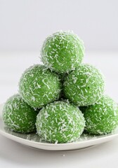 Fototapeta premium Indonesian klepon rice balls with coconut, isolated on white background, clean dessert stock photo for culinary projects.