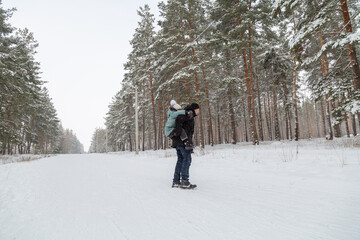 Dad and daughter walking and having fun in snowy winter forest