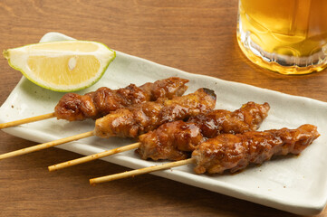 美味しそうにてかっている焼き鳥とビールの注がれたジョッキ