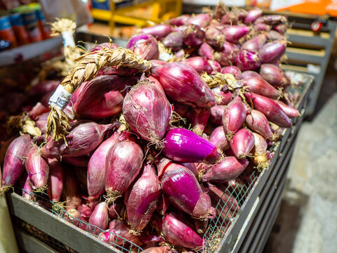 The red onion from Tropea, Italy. Large piles of red, pink onion at the market in Calabria town Tropea.
