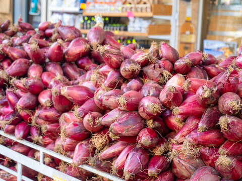 The red onion from Tropea, Italy. Large piles of red, pink onion at the market in Calabria town Tropea.
