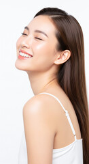 Happy Asian woman with clean glowing skin, smiling with eyes closed in satisfaction.
