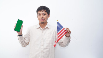 Asian Man holding green screen smartphone with USA flag at studio against white background