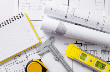 Architects concept, project house, Construction plans with yellow helmet and drawing tools on...