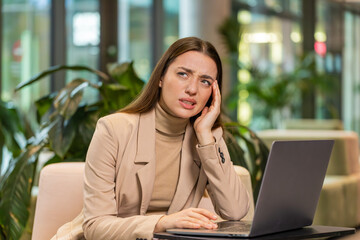 Tired Caucasian businesswoman freelancer girl use laptop, suffering from headache problem tension,...