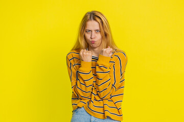 Upset frustrated annoyed Caucasian blonde woman in blouse raising hands in indignant expression,...
