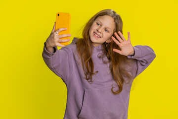Happy preteen child girl kid blogger taking portrait selfie on smartphone, communicating record...