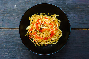 Spaghetti with tomato sauce shot on rustic wooden table