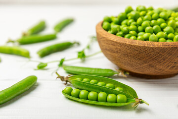 Fresh green pea pods with green peas on a wooden background. Sweet green peas. Green pea beans vegetables. Vegan. healthy vegetable. Copy space