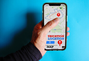 Mapa navegador con ubicación, localización y ruta track en la aplicación del teléfono móvil en la mano con fondo azul