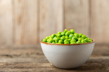 Fresh green pea pods with green peas on a wooden background. Sweet green peas. Green pea beans vegetables. Vegan. healthy vegetable. Copy space