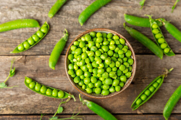 Fresh green pea pods with green peas on a wooden background. Sweet green peas. Green pea beans vegetables. Vegan. healthy vegetable. Copy space