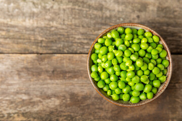 Fresh green pea pods with green peas on a wooden background. Sweet green peas. Green pea beans vegetables. Vegan. healthy vegetable. Copy space