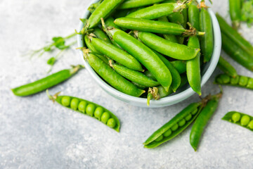 Fresh green pea pods with green peas on a wooden background. Sweet green peas. Green pea beans vegetables. Vegan. healthy vegetable. Copy space