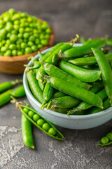 Fresh green pea pods with green peas on a wooden background. Sweet green peas. Green pea beans vegetables. Vegan. healthy vegetable. Copy space