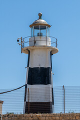 The old black and white lighthouse in the walled city of Old Acre, Akko Israel.
