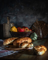 Fresh baked goods, apples and pumpkins on a rustic table