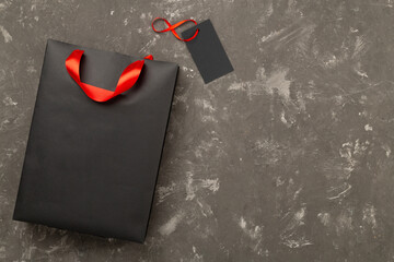 Black shopping bag on concrete background, top view.Black Friday concept