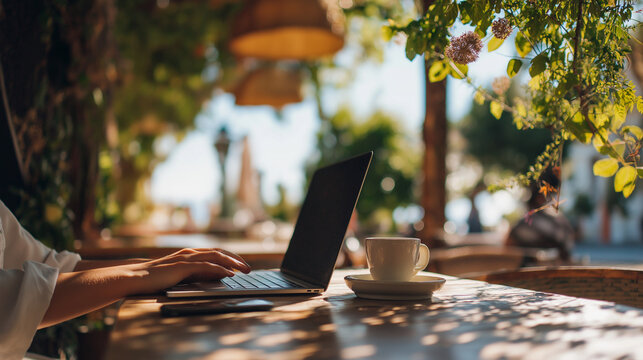 digital nomad working on laptop at outdoor cafe