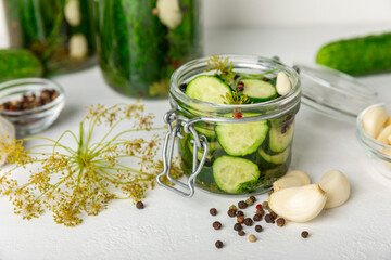 Freshly-salted homemade cucumbers in a jar on a wooden background. pickled cucumbers with dill,garlic and pepper.canned cucumbers.cucumbers and dill.Recipe of homemade preservations.fermented veggies.
