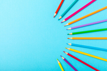 Colored pencils on a bright colored background. Equipment for coloring. Stationery for...