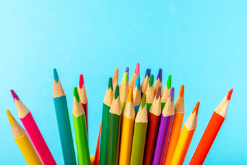 Colored pencils on a bright colored background. Equipment for coloring. Stationery for...