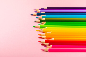 Colored pencils on a bright colored background. Equipment for coloring. Stationery for...