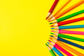 Colored pencils on a bright colored background. Equipment for coloring. Stationery for...