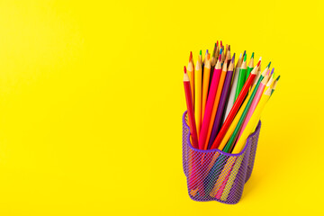 Colored pencils on a bright colored background. Equipment for coloring. Stationery for...